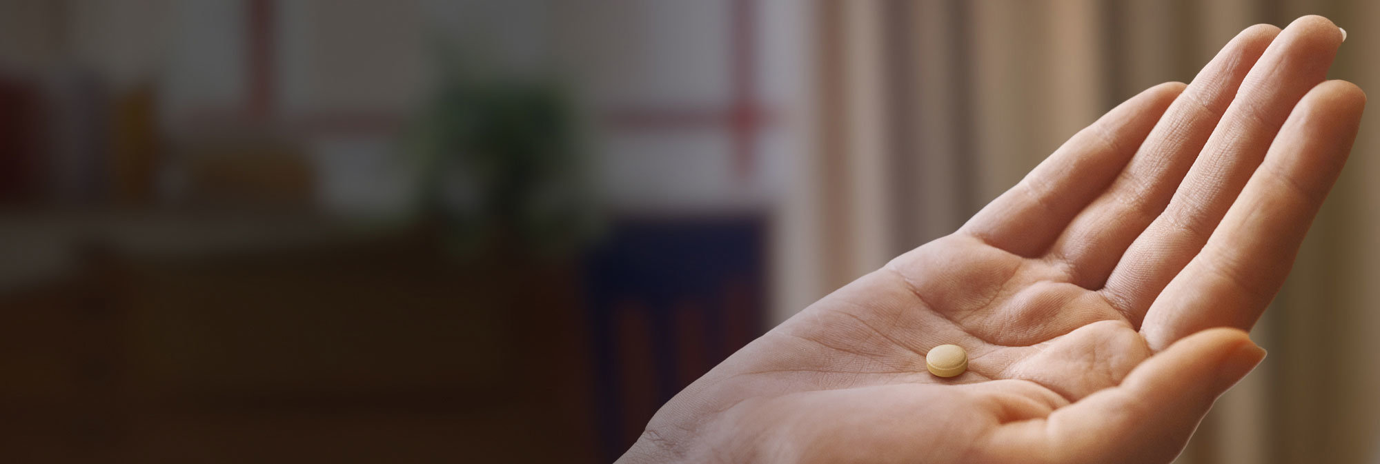 Pill in hand hero image. Patient portrayal; pill not actual size.