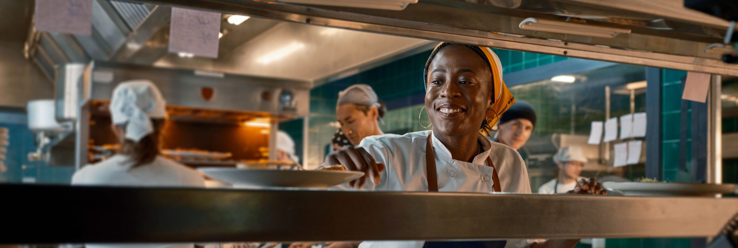 Chef examining a plated dish in a professional kitchen setting.